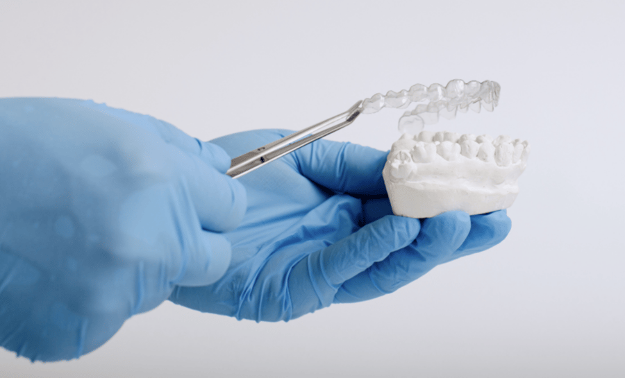 Dentists hand holding clear aligners