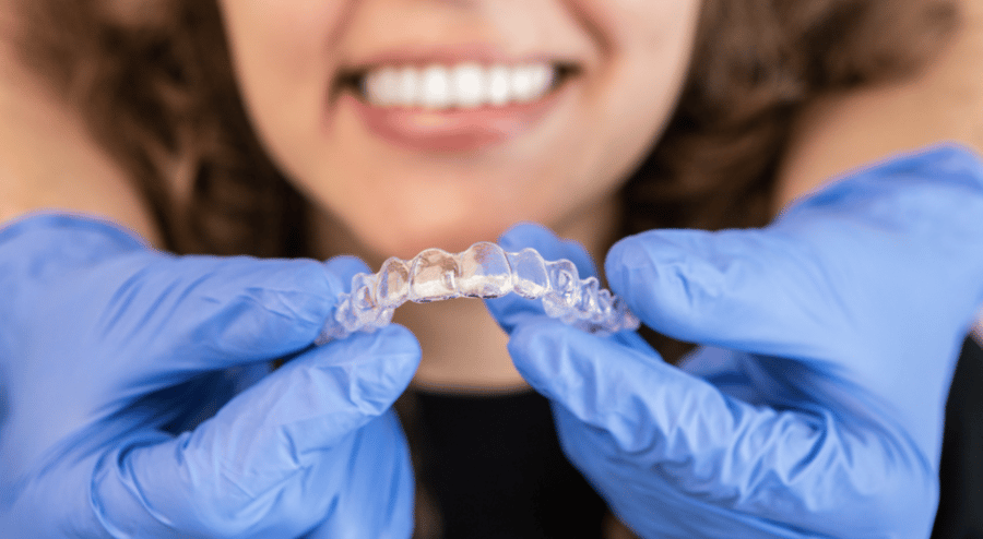Dentist fitting aligners on patient