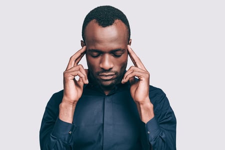 Black man with headache, rubbing temples