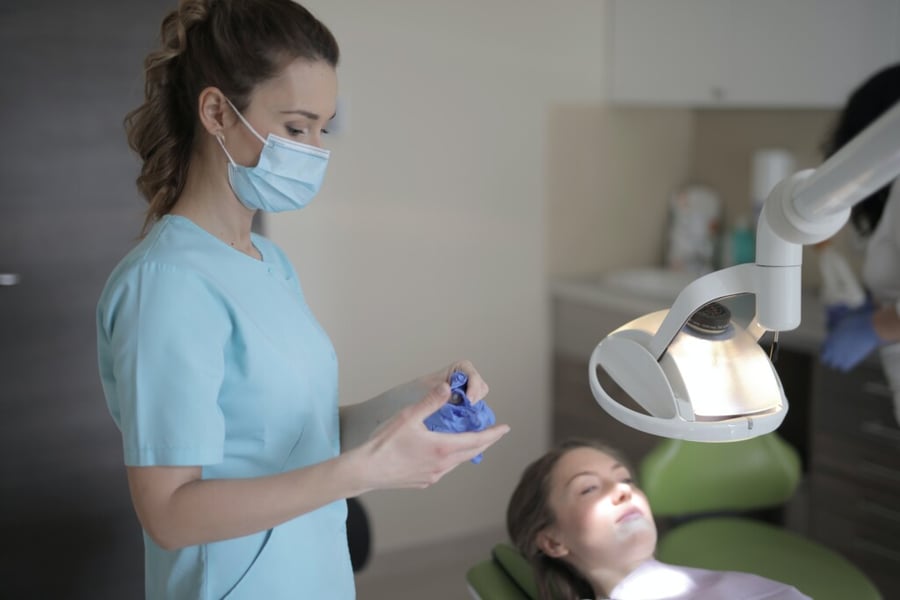 Dentist assisting patient